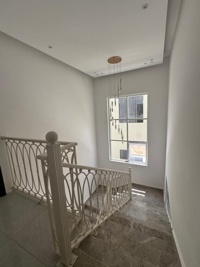 سلم أبيض أنيق يربط بين غرف الفيلا بتصميم عصري وجذاب