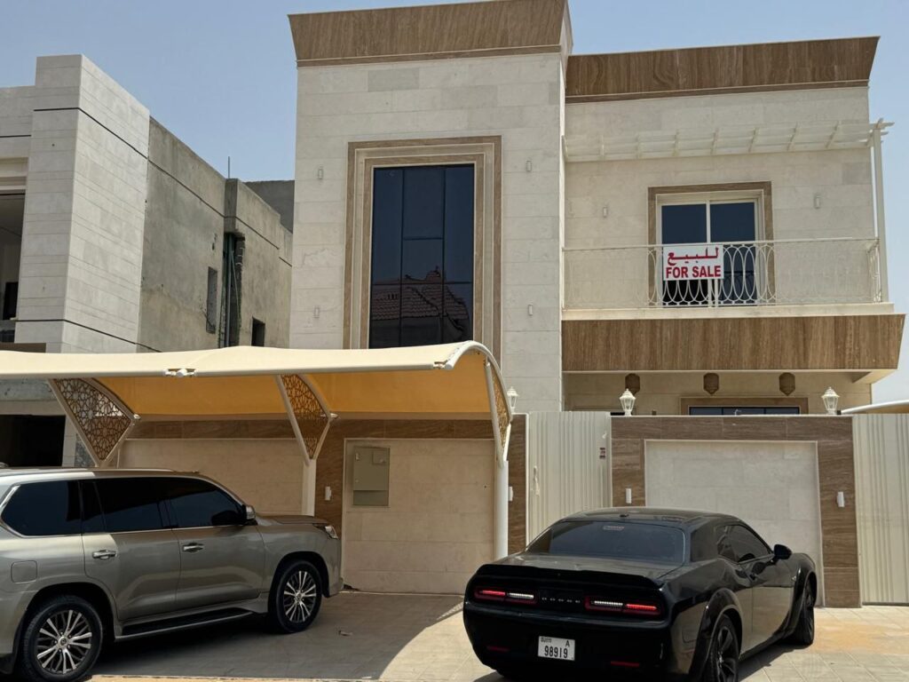 الواجهة الخارجية لفيلا راقية وفخمة في منطقة الحليو، عجمان، تظهر التصميم العصري والأناقة المعمارية.